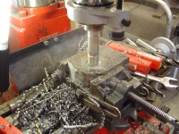  Using a cutting tool to make the 35mm holes in the fabricated top mounts